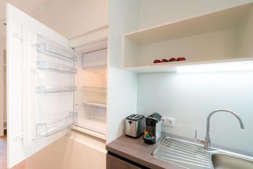 a kitchen with a sink and an empty refrigerator at Vienna Residence, Hietzing - Schönbrunn in Vienna