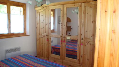1 dormitorio con armario de madera y cama. en Appartement Les Clarines, en Les Houches