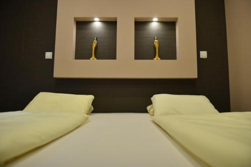 a bedroom with two beds and two pictures of giraffes at Apartman Centar in Brčko