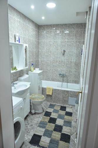 a bathroom with a sink and a toilet and a tub at Apartman Centar in Brčko