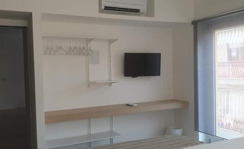 Zimmer mit einem Bett und einem TV an der Wand in der Unterkunft Xenia, B&B Soverato in Soverato Marina