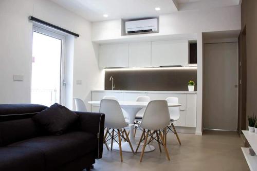 ein Wohnzimmer mit einem Tisch und Stühlen sowie eine Küche in der Unterkunft Xenia, B&B Soverato in Soverato Marina