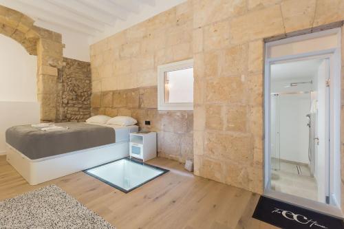 een slaapkamer met een bed en een stenen muur bij studio cave in Palma de Mallorca