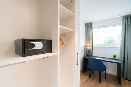 a small room with a desk and a tv on a wall at Vienna Residence, Hietzing - Schönbrunn in Vienna
