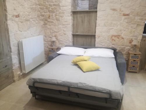 a bed with two pillows on it in a room at Trulli Manuela 1 in Locorotondo