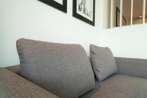 a couch sitting in a living room with two pillows at Vienna Residence, Hietzing - Schönbrunn in Vienna