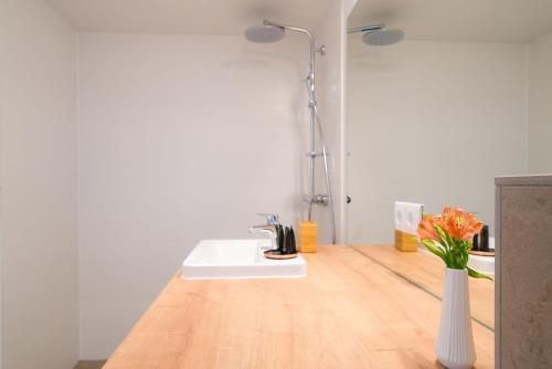 a bathroom with a sink and a vase with flowers at Vienna Residence, Hietzing - Schönbrunn in Vienna