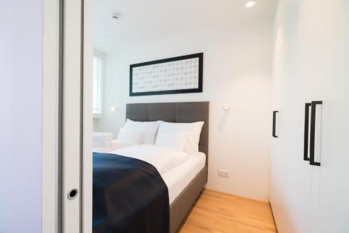 a bedroom with a large bed with white sheets at Vienna Residence, Hietzing - Schönbrunn in Vienna
