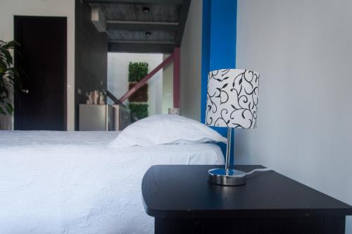 een bed met een tafel met een lamp erop bij Apartamento 12 Cali Sur in Cali