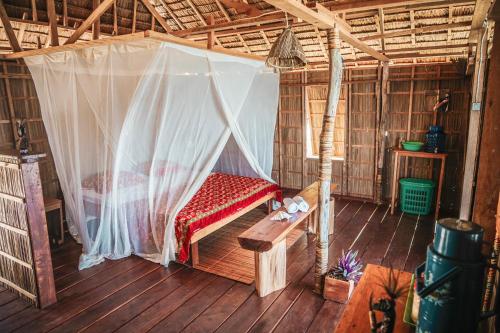 a bed in a room with a net at Methos Homestay - Raja Ampat in Yennanas Besir