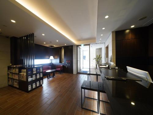a lobby of a building with a counter and chairs at Meitetsu Inn Nagoya Sakuradori in Nagoya
