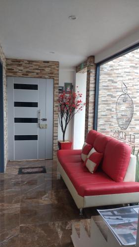 a living room with a red couch and a door at HOTEL EL EDEN IXTAPALUCA in Ixtapaluca