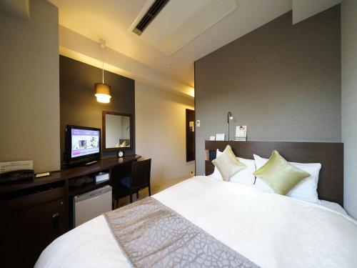 Habitación de hotel con cama y TV en Meitetsu Inn Nagoya Sakuradori, en Nagoya