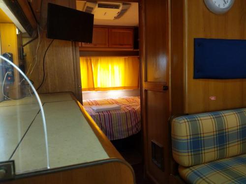 Piccola camera con letto e TV in treno di INTO THE WILD - CAMPER a Montargano