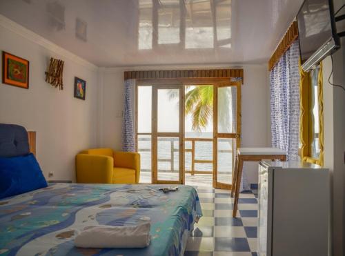 プロビデンシアにあるPosada Ocean Viewのベッドルーム1室(ベッド1台、椅子、窓付)