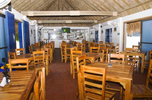 an empty restaurant with wooden tables and chairs at Awa De Mar Hotel in Tolú