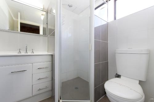 y baño blanco con aseo y ducha. en Comfort Inn Dubbo City, en Dubbo