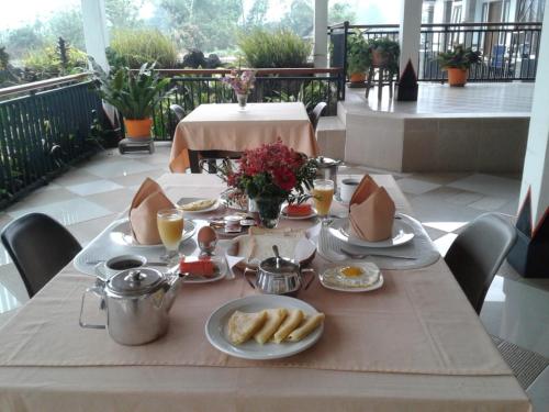 a table with breakfast food on a balcony at Toraja Torsina Hotel in Rantepao
