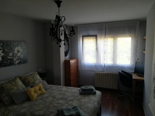 um quarto com uma cama, uma secretária e uma janela em Javi em Gijón