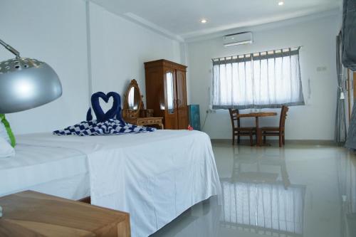 a bedroom with a bed with a blue pillow on it at Karma Amed Guesthouse in Amed