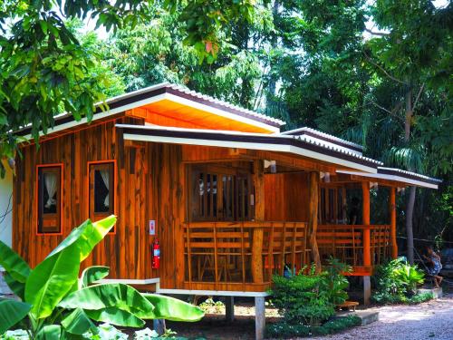 a small wooden cabin in the middle of trees at Baansuan Resort in Don Sak