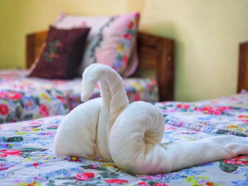 a stuffed swan is laying on a bed at Baansuan Resort in Don Sak