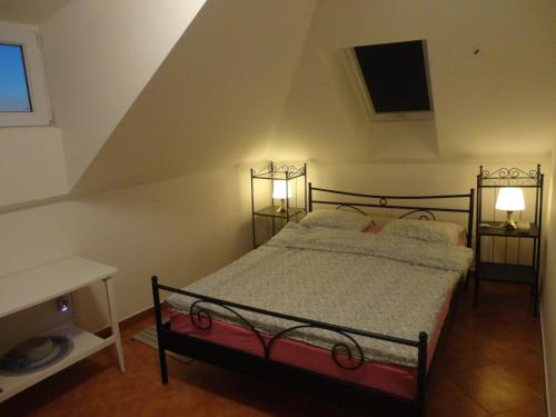 a bedroom with a bed and two lamps in a attic at Apartment Gliha in Jelsa