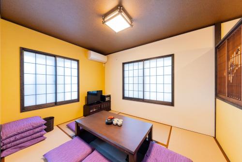 a room with a table and two windows at YADOYA Sennokaze in Tokyo