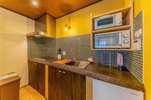 a kitchen with a sink and a microwave at YADOYA Sennokaze in Tokyo