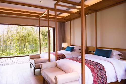 two beds in a room with a balcony at Evergreen Retreat-walk to National Forest Park, free pick up service in Zhangjiajie