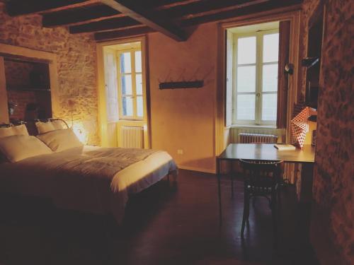 1 dormitorio con 1 cama, escritorio y ventanas en Olivia Suite Charme&Relax, en Bérgamo