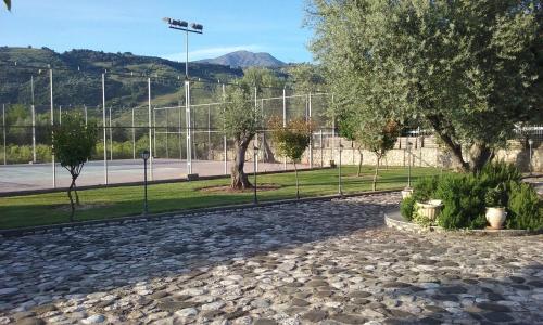 a park with trees and a fence and a street light at STUDIO WITH TENIS COURT AND MINI BASKET in Aigio