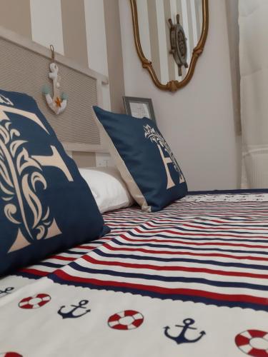 Cama con sábanas y almohadas azules y blancas en Finestra Azzurra, en San Vito lo Capo