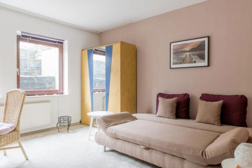 ein Wohnzimmer mit einem Sofa und einem Fenster in der Unterkunft Private Apartment in Hannover