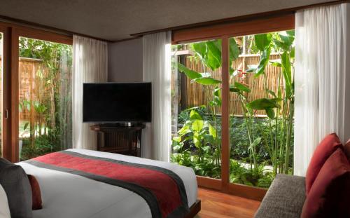 a bedroom with a bed and a large window at Anantara Rasananda Koh Phangan Villas in Thong Nai Pan Noi