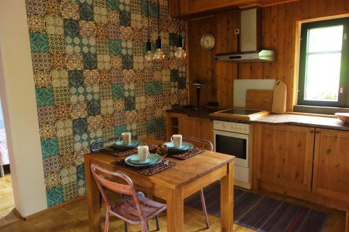eine Küche mit einem Holztisch und Stühlen sowie einem Tisch und einem Herd in der Unterkunft FeWo Schuster in Garlstorf