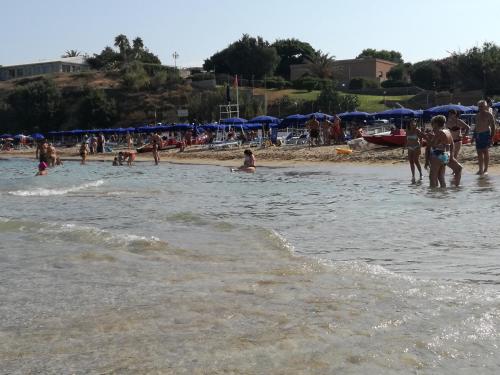 a group of people in the water at a beach at Terra Sinus Holiday House in Terrasini