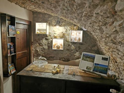 a desk with a computer on top of a stone wall at Residenza La Torre in Santo Stefano di Sessanio