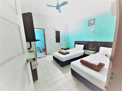 a hotel room with two beds and a tv at Singapore Hotel in Hat Yai