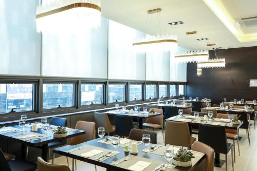un ristorante con tavoli, sedie e finestre di Ramada by Wyndham Daejeon a Daejeon