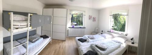 a bedroom with two bunk beds and two windows at Det Bette Hus in Hjørring