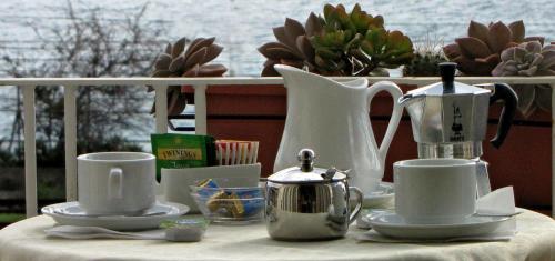 einen Tisch mit Tassen und Teezubehör in der Unterkunft B&B Agon in Taormina