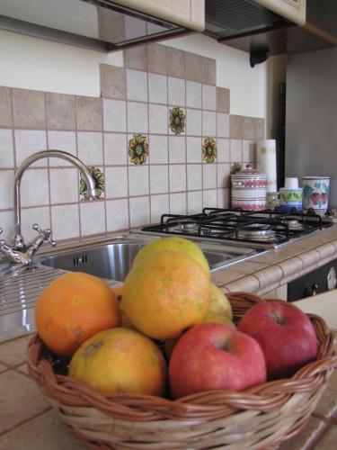 ein Korb mit Äpfeln und Birnen neben einer Spüle in der Unterkunft B&B Agon in Taormina