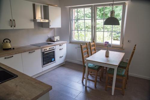 a kitchen with a table and chairs and a window at Oelgemoellers Hus in Lohne