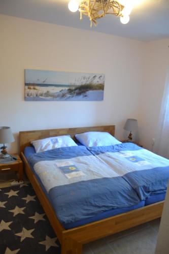 a bedroom with a bed with a blue comforter at Ferienwohnung Eckernforde in Eckernförde