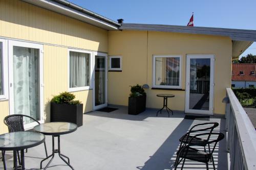a patio with tables and chairs next to a building at NORDVIG bed & breakfast in Sandvig