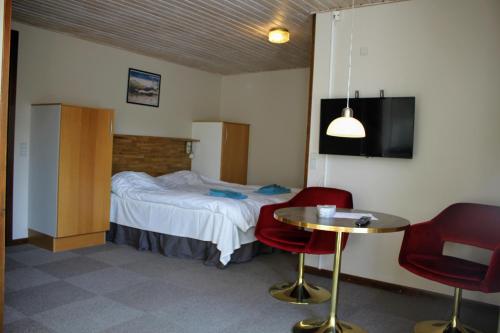 a hotel room with a bed and a table and chairs at NORDVIG bed & breakfast in Sandvig