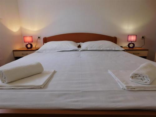 duże białe łóżko z dwoma ręcznikami i dwoma lampami w obiekcie Charming apartment Karlo w mieście Betina