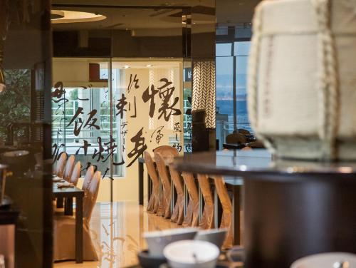 a table and chairs in a restaurant with asian writing on the wall at Freshfields Hotel in Wuri