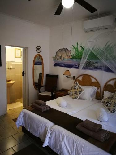 a bedroom with a large white bed in a room at Bhangazi Lodge Bed & Breakfast in St Lucia